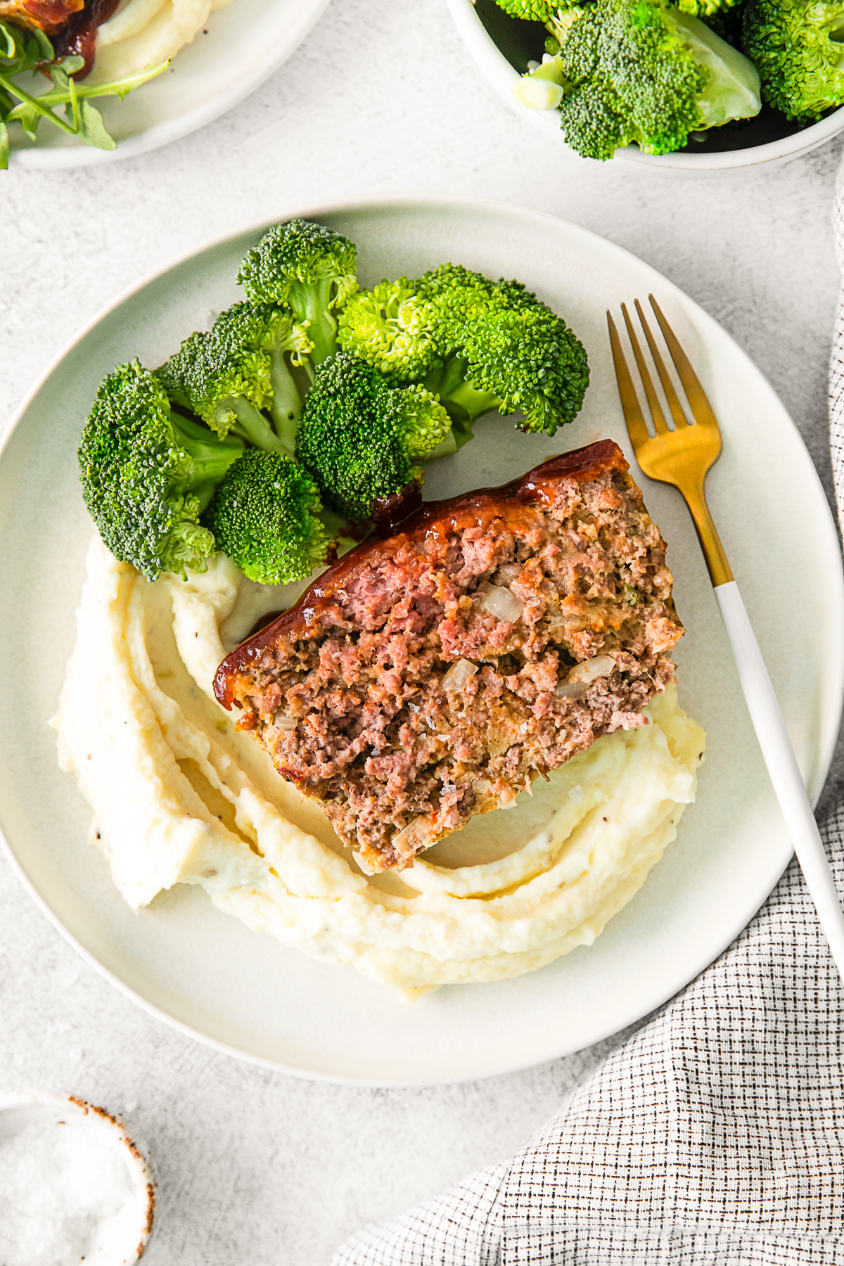 BBQ Glazed Meatloaf on a plate with broccoli. 