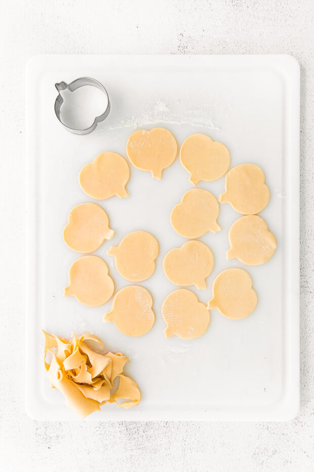 Pie dough cut out into pumpkin shapes. 