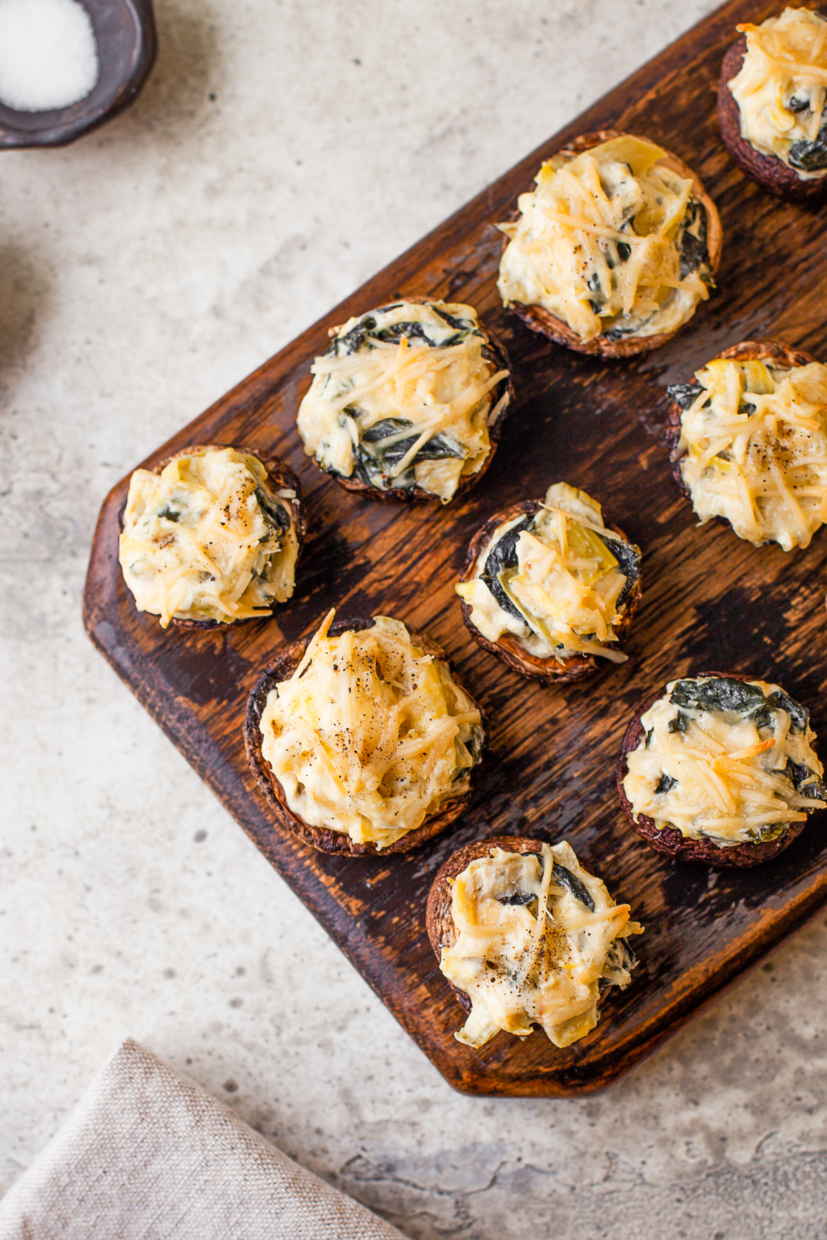Spinach Artichoke Stuffed Mushrooms topped with Parmesan cheese. 