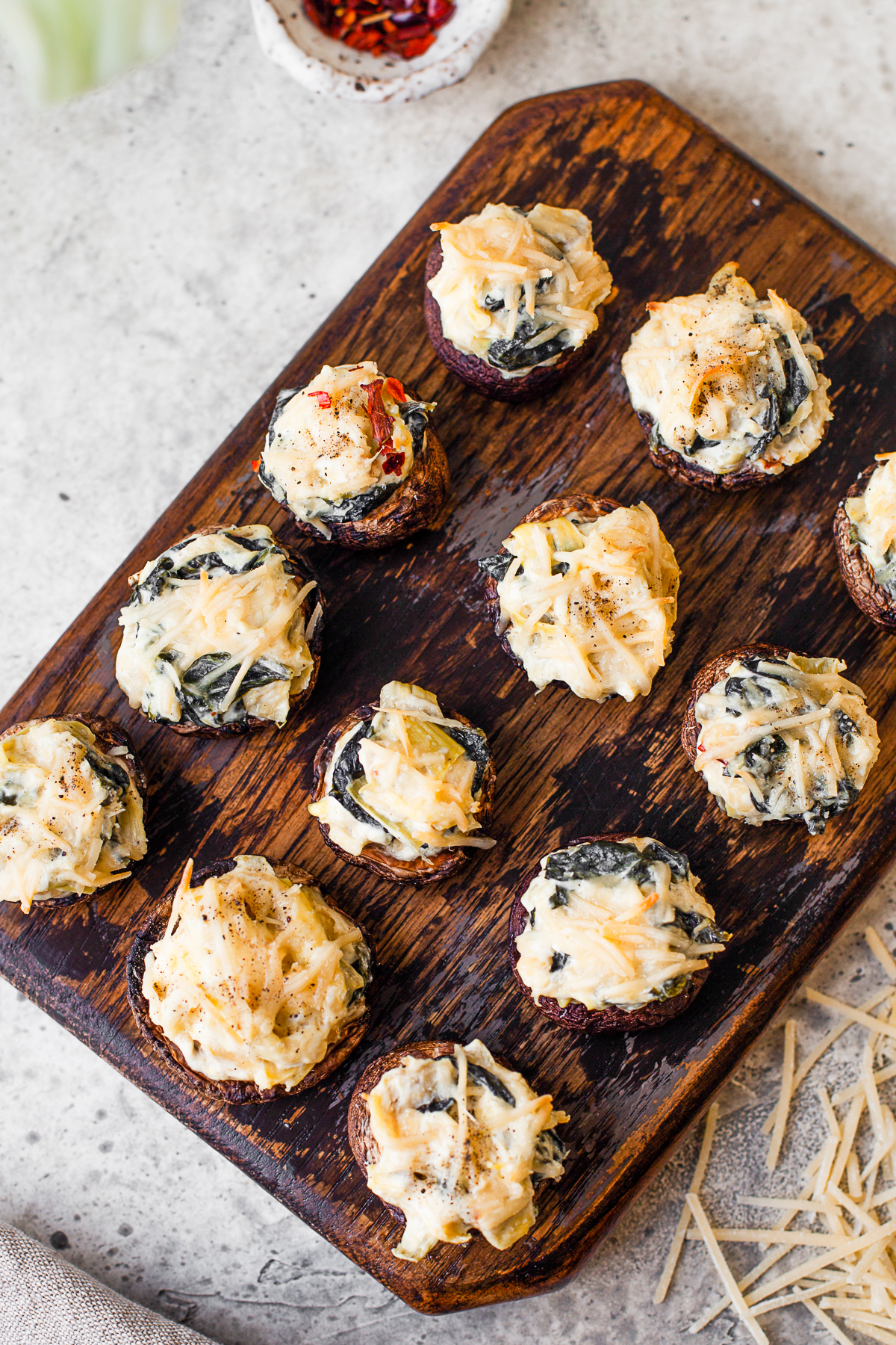 Spinach Artichoke Stuffed Mushrooms topped with cheese. 