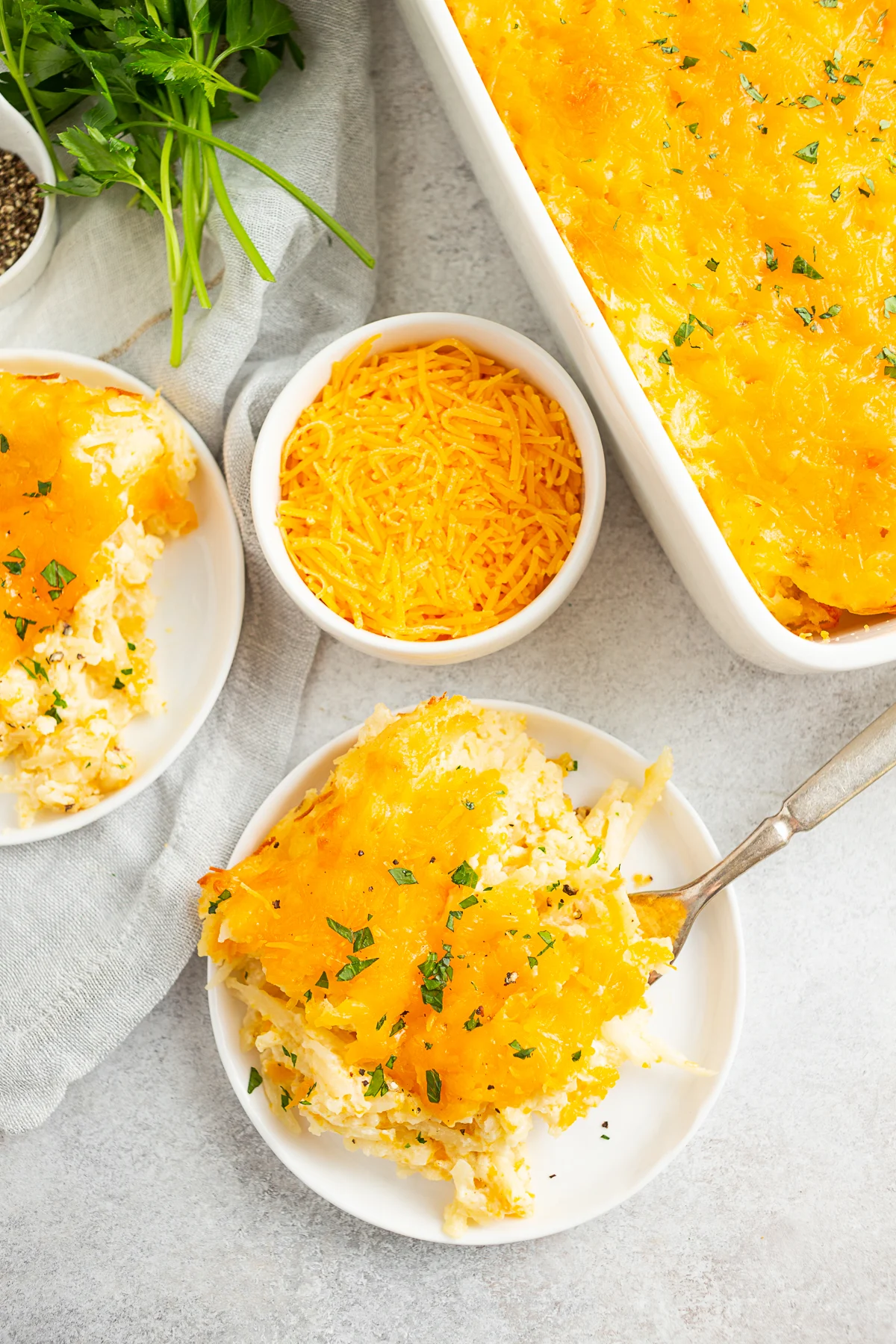 Cheesy Potatoes (Funeral Potatoes) served with a sprinkle of parsley. 