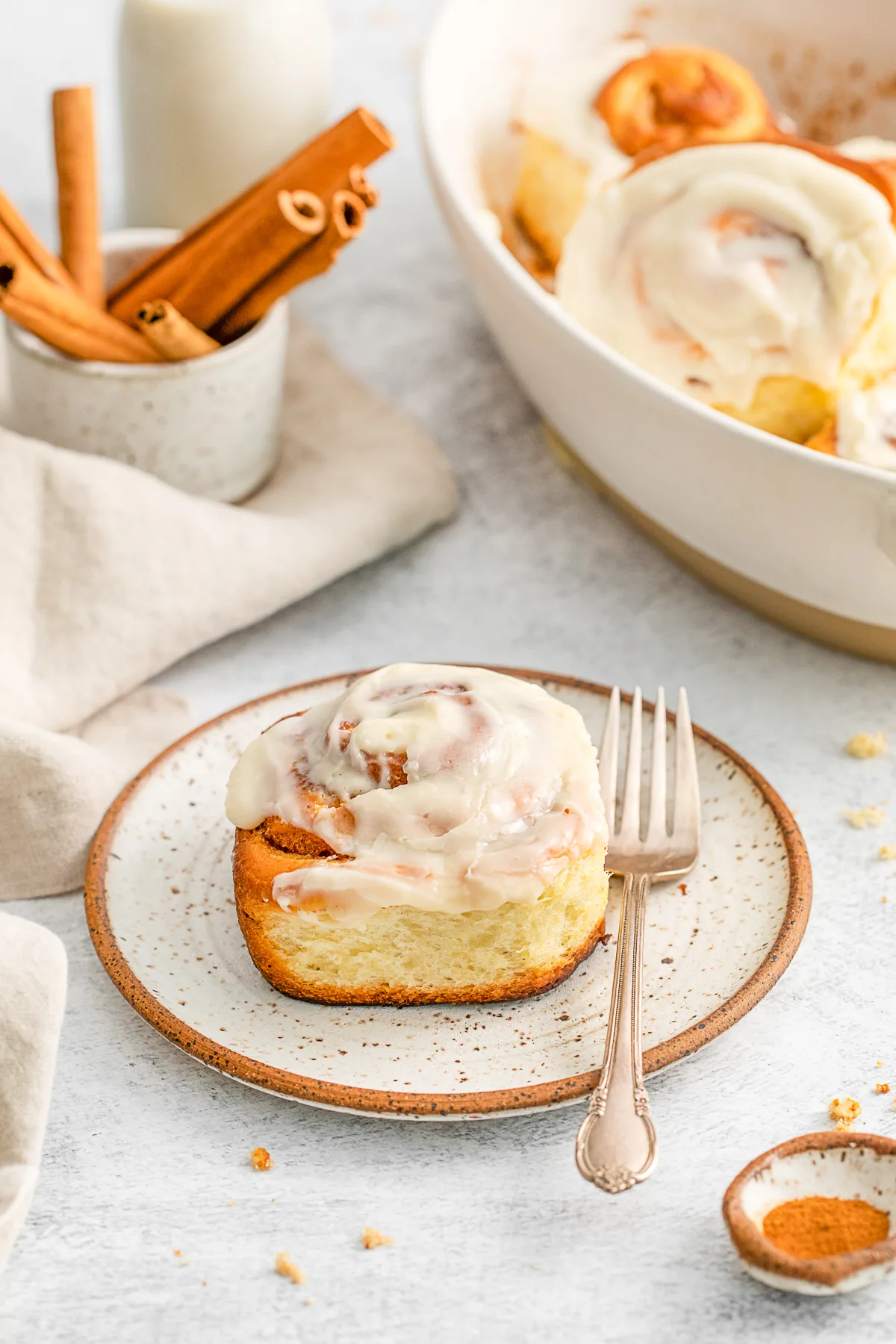 Cinnamon roll on a plate with a fork. 