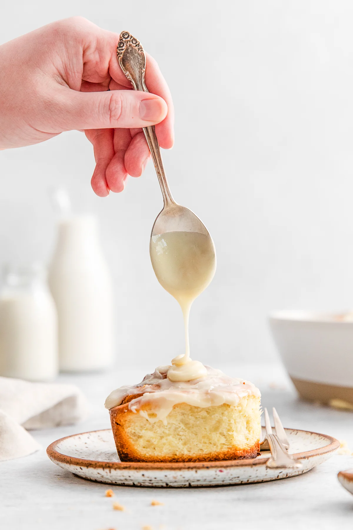 Cream cheese frosting drizzled on a cinnamon roll. 