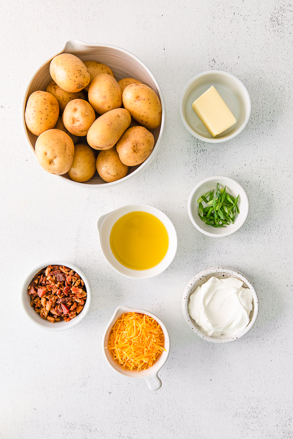 Ingredients to make Mini Loaded Baked Potatoes on a table. 