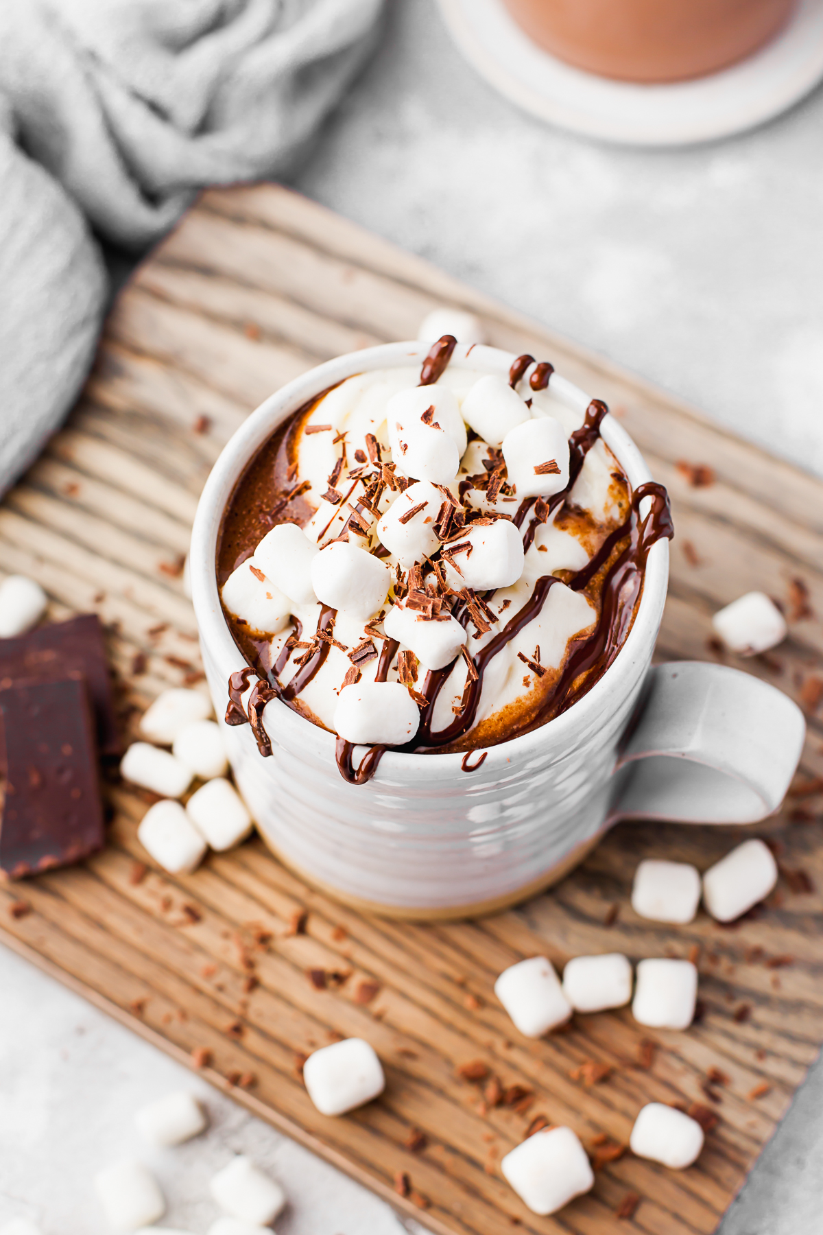 Slow Cooker Hot Chocolate topped with marshmallows and chocolate sauce. 