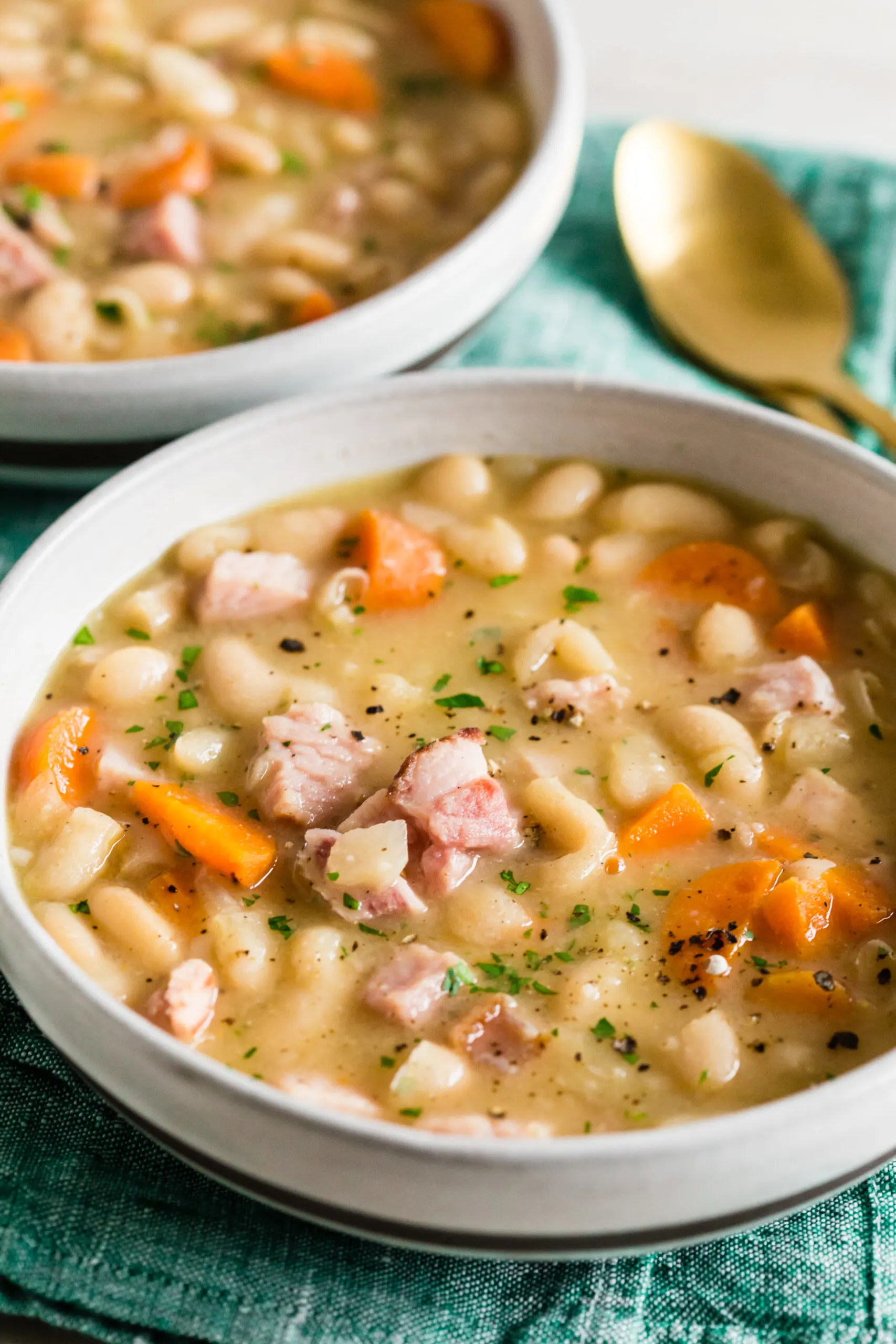 easy ham and bean soup in a bowl sprinkled with fresh herbs.