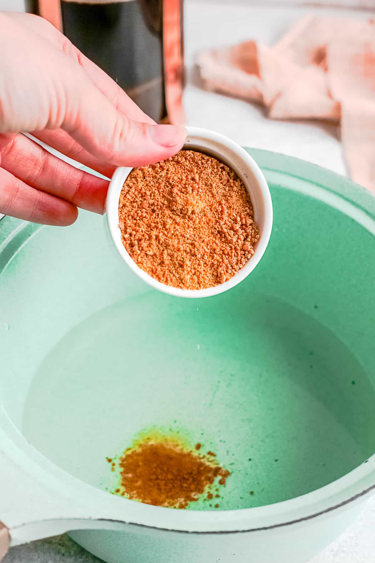 Brown sugar being poured into water.