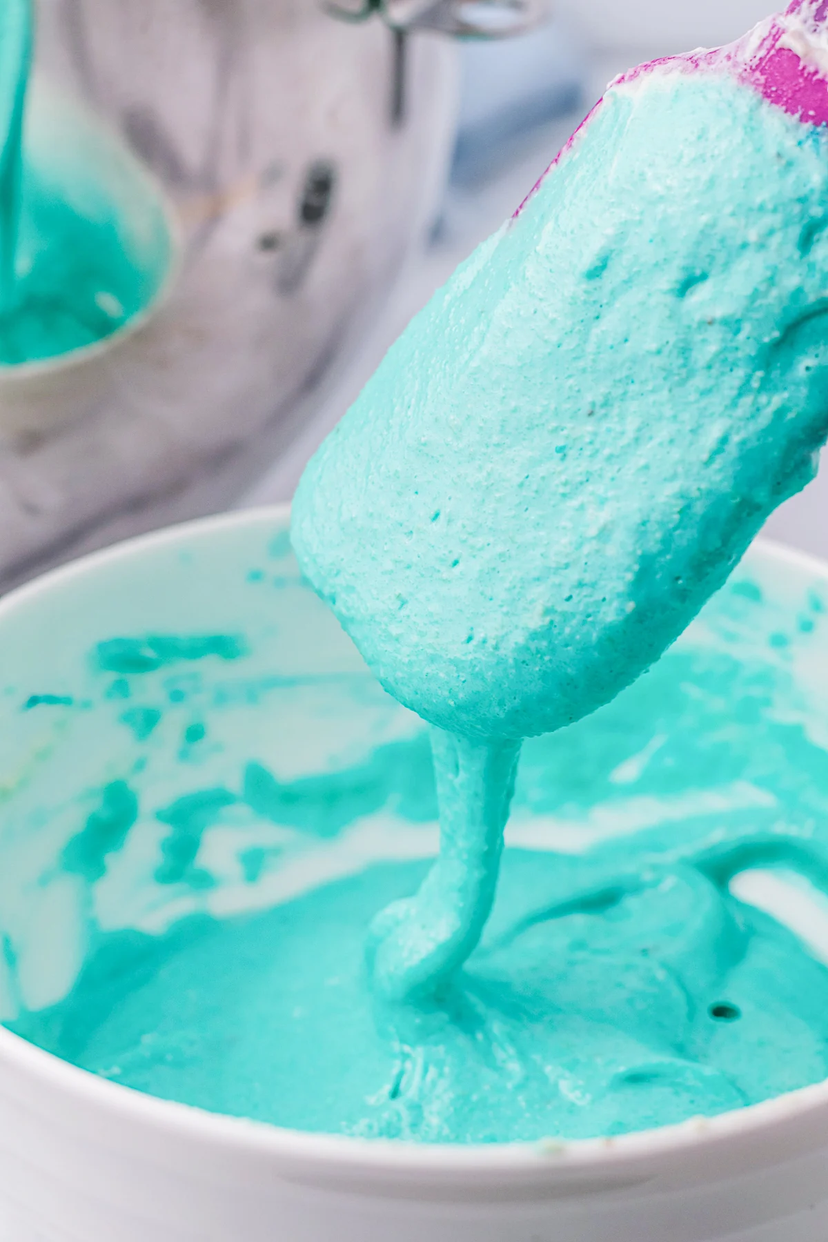 Beating in blue food coloring to a macaron batter. 
