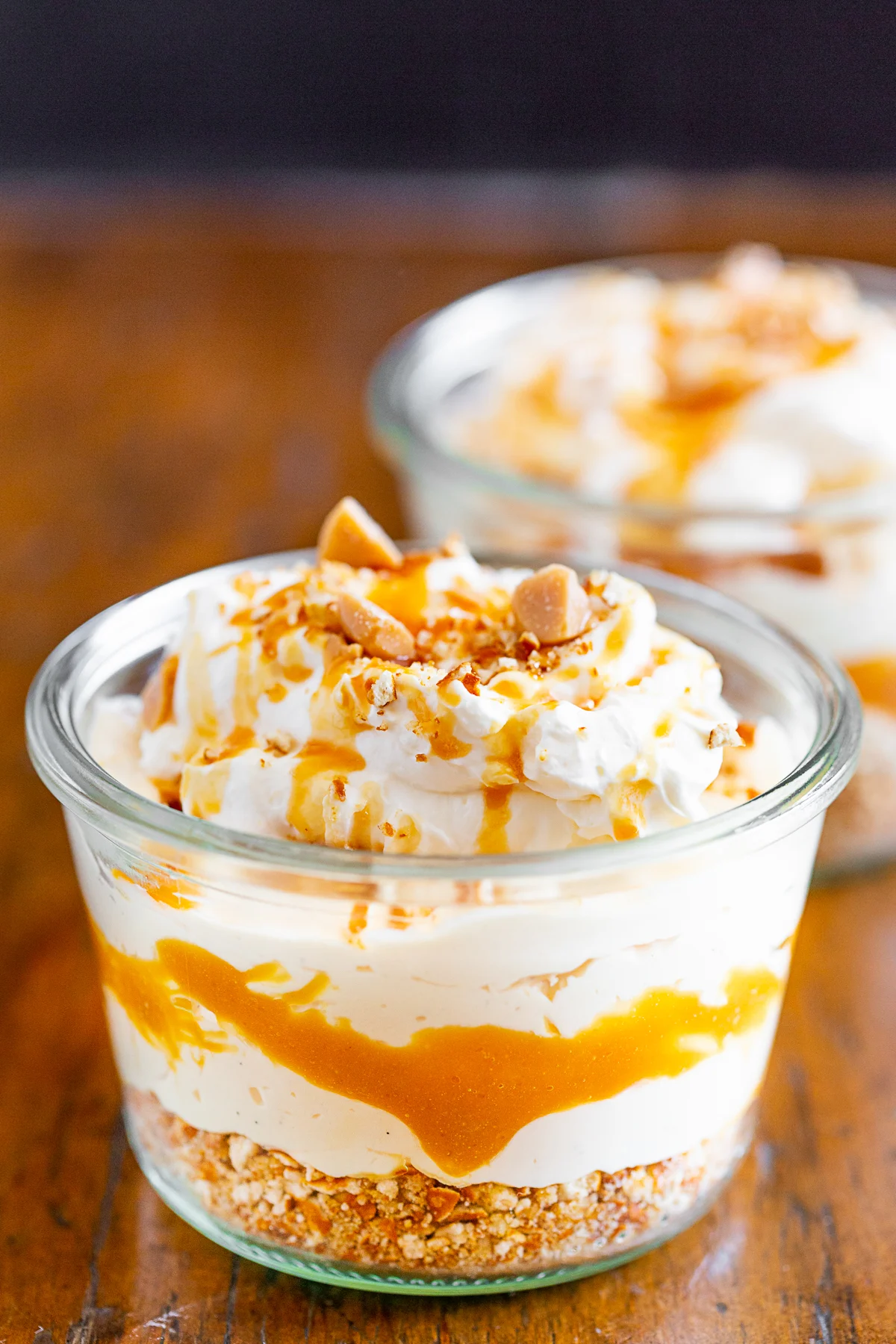 No Bake Caramel Cheesecake in a jar showing layers of filling and caramel. 