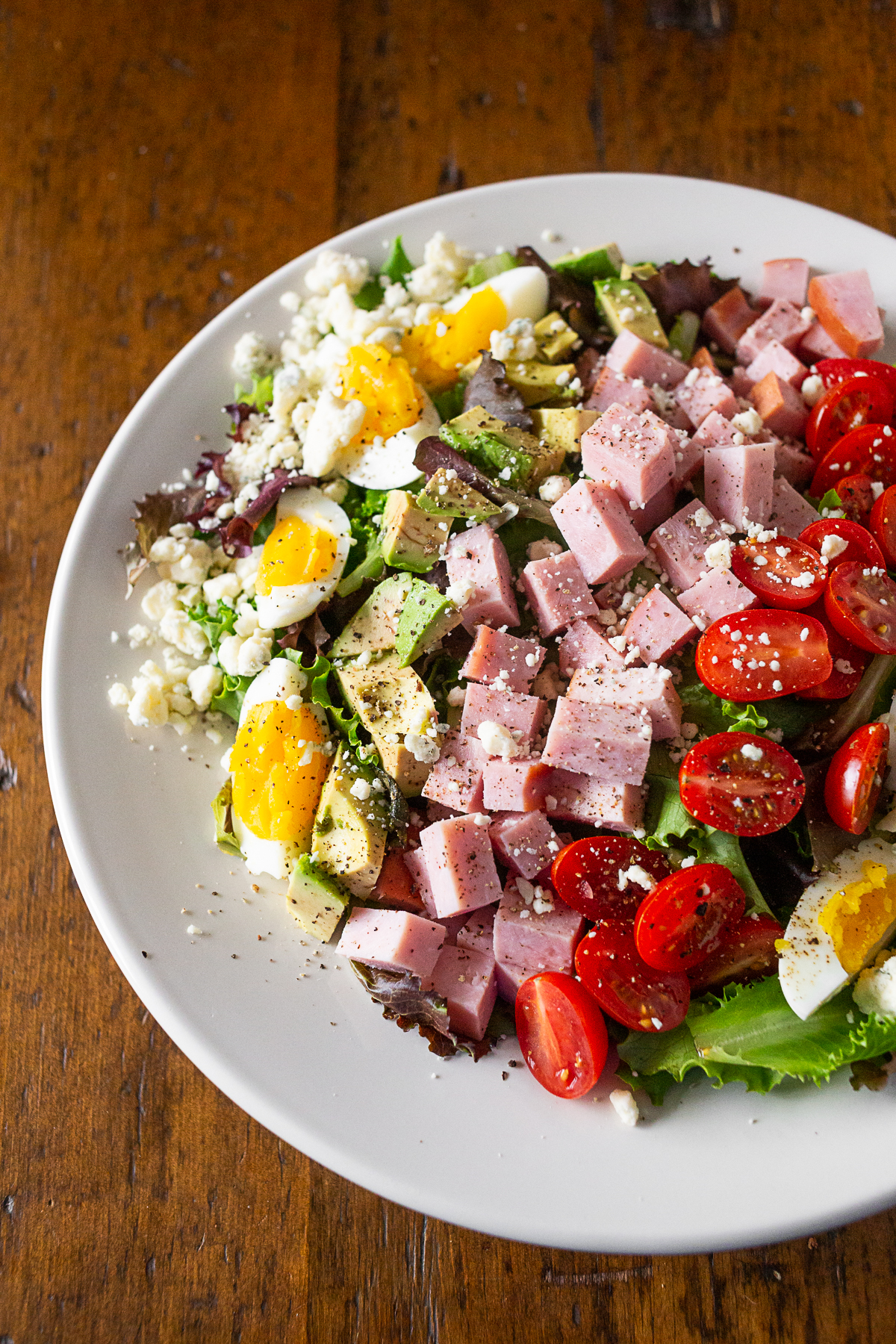 Ham Cobb Salad in a white bowl on a table. 